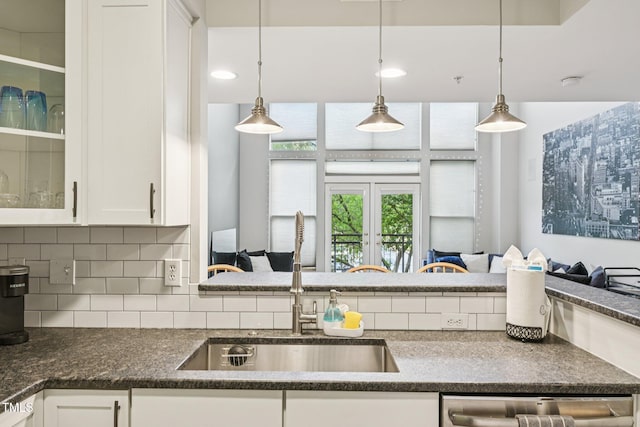 200 S Dawson St Unit 114, Raleigh, NC 27601 - kitchen with dark countertops, white cabinets, tasteful backsplash, glass insert cabinets, and stainless steel dishwasher