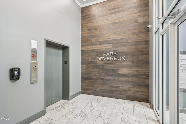200 S Dawson St Unit 114, Raleigh, NC 27601 - hall featuring wooden walls, elevator, marble finish floors, a high ceiling, and crown molding