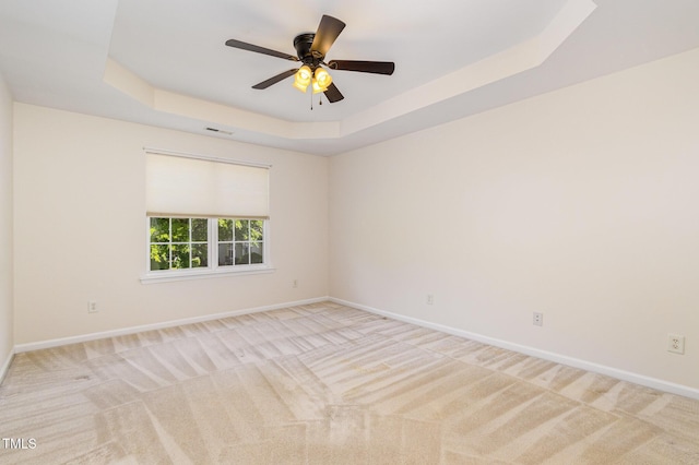 unfurnished room featuring a raised ceiling, baseboards, carpet, and visible vents