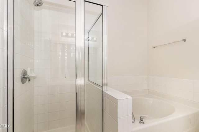 bathroom featuring a garden tub and a stall shower