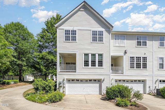 multi unit property with an attached garage, cooling unit, and concrete driveway