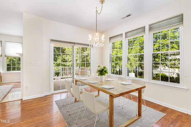 4002 Cherry Blossom Cir, Durham, NC 27713 - dining area with a healthy amount of sunlight, baseboards, light wood finished floors, and a notable chandelier