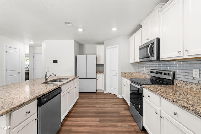 224 Brisk Dr, Zebulon, NC 27597 - kitchen featuring appliances with stainless steel finishes, a sink, dark wood-type flooring, tasteful backsplash, and white cabinets