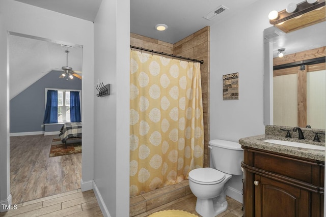 bathroom with wood finished floors, toilet, a ceiling fan, vanity, and curtained shower