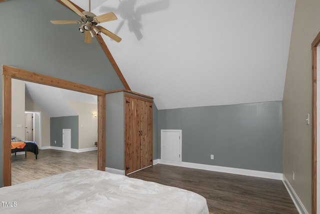 bedroom featuring vaulted ceiling, wood finished floors, baseboards, and a ceiling fan