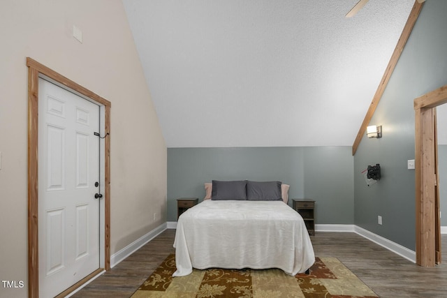 bedroom featuring wood finished floors, lofted ceiling, and baseboards