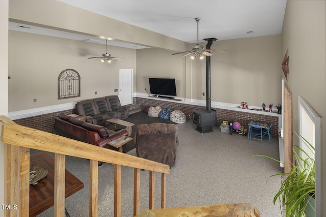 living room featuring a ceiling fan and a wood stove