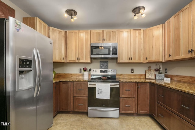 kitchen with appliances with stainless steel finishes, light stone counters, and light brown cabinets