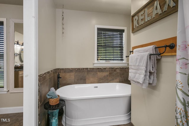full bath featuring a freestanding bath and tile patterned flooring