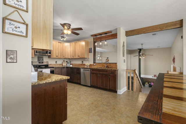 kitchen with appliances with stainless steel finishes, a ceiling fan, stone counters, and a sink