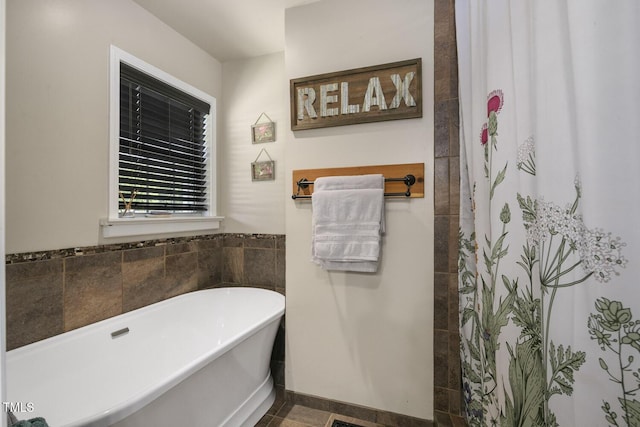 bathroom featuring a freestanding bath and curtained shower