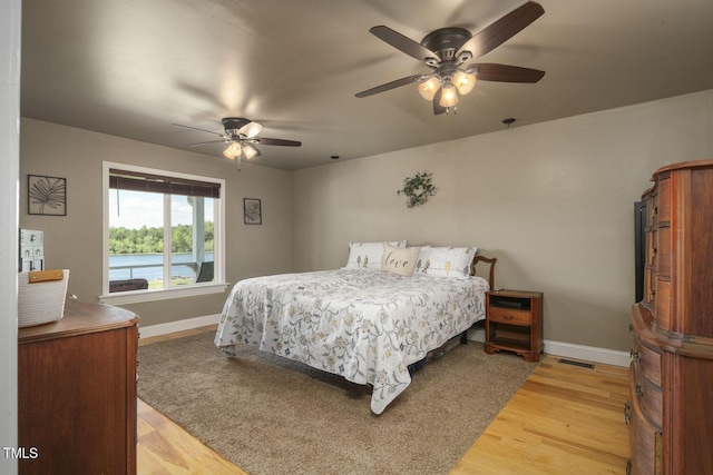 bedroom with baseboards, light wood finished floors, and ceiling fan