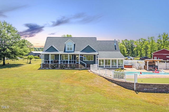 back of house featuring a sunroom, roof with shingles, and a porch