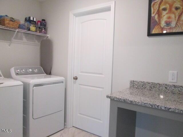 laundry room featuring separate washer and dryer, laundry area, and marble finish floor