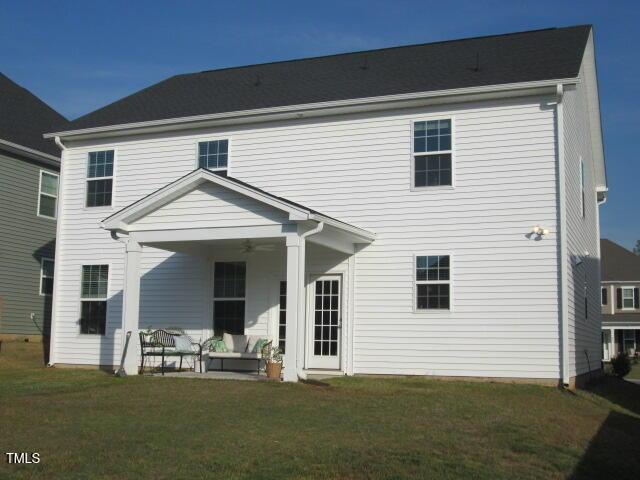 rear view of property featuring a lawn, ceiling fan, and a patio area