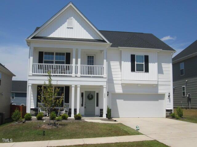 view of front of house featuring covered porch, board and batten siding, a balcony, concrete driveway, and an attached garage