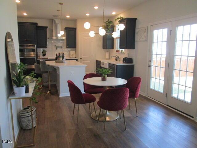 dining area featuring recessed lighting, a wealth of natural light, and dark wood-type flooring
