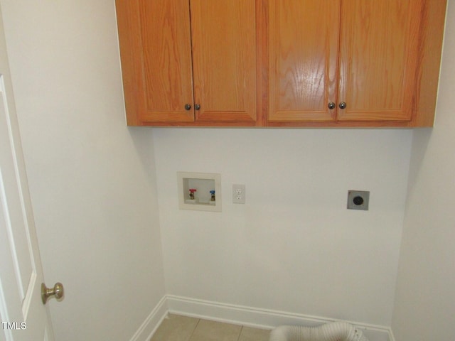 laundry area featuring washer hookup, electric dryer hookup, tile patterned flooring, cabinet space, and baseboards
