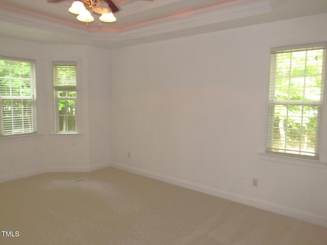 unfurnished room featuring a ceiling fan, baseboards, ornamental molding, a tray ceiling, and carpet flooring