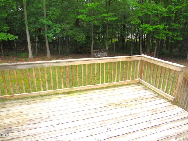 wooden deck featuring a lawn