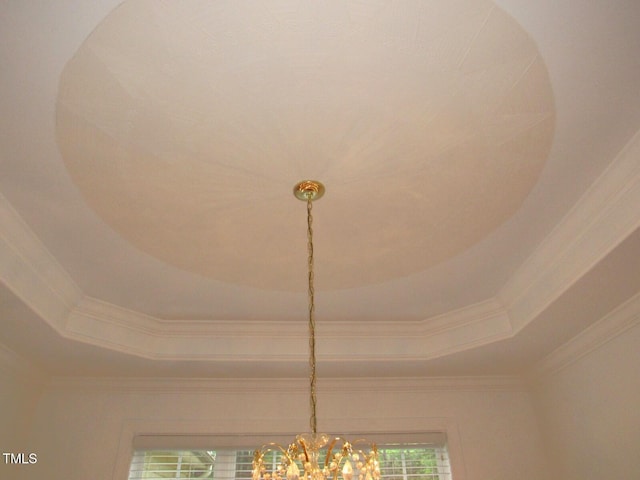 interior details with crown molding, a tray ceiling, and a notable chandelier