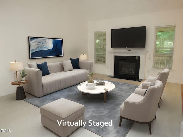 living area with baseboards and a glass covered fireplace