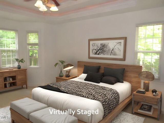 bedroom with a tray ceiling, ornamental molding, and wood finished floors