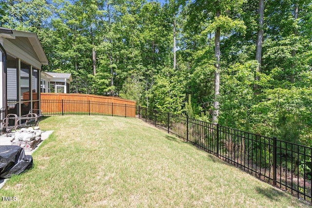 view of yard featuring a fenced backyard and a sunroom