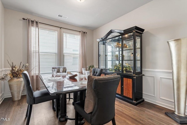 dining room with wainscoting, wood finished floors, and visible vents