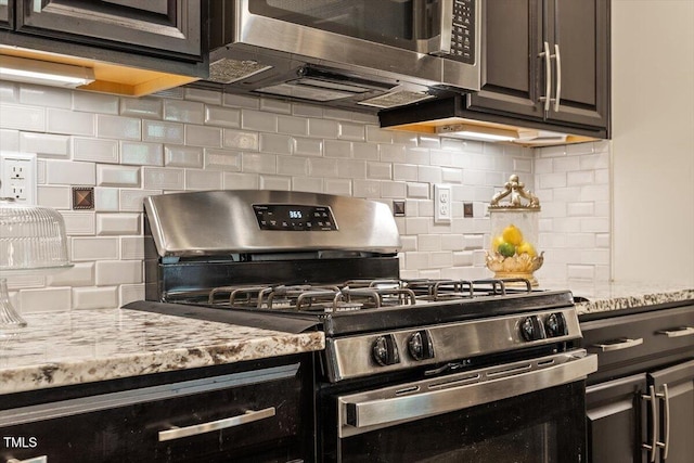 kitchen featuring appliances with stainless steel finishes, decorative backsplash, and light stone countertops