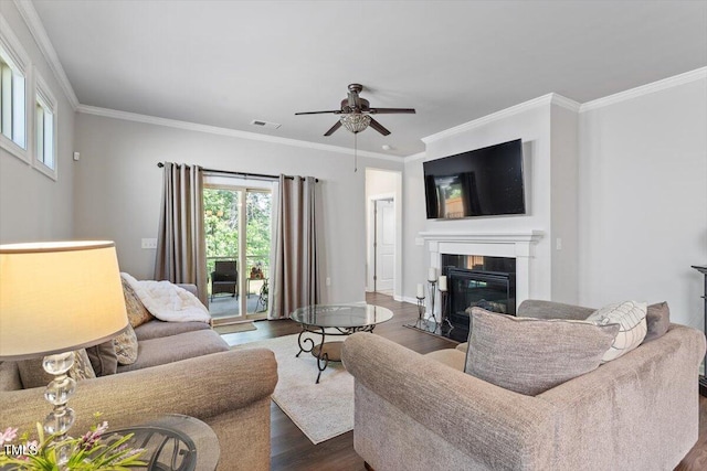 living area featuring crown molding, dark wood-style flooring, ceiling fan, and a wealth of natural light
