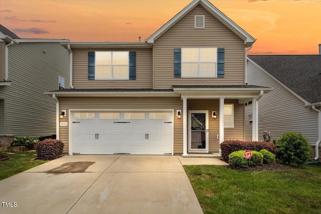 traditional-style house with a yard, an attached garage, and concrete driveway