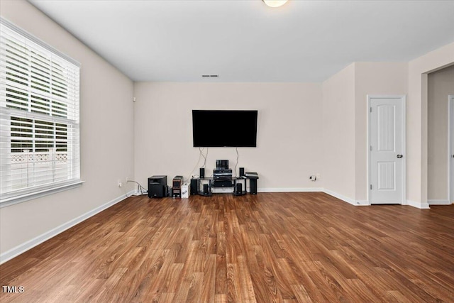 living room featuring baseboards, wood finished floors, and visible vents