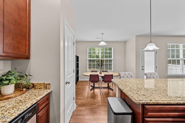 kitchen with pendant lighting, light stone counters, and wood finished floors