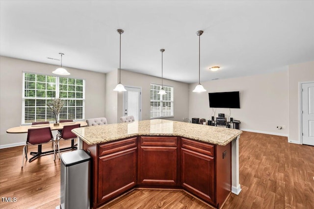 kitchen with baseboards, plenty of natural light, and wood finished floors