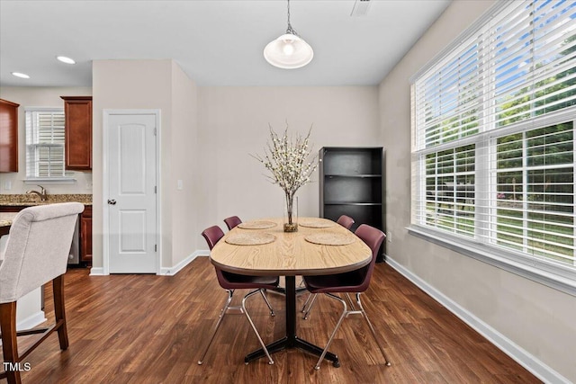 dining space featuring baseboards, dark wood-style floors, and a wealth of natural light