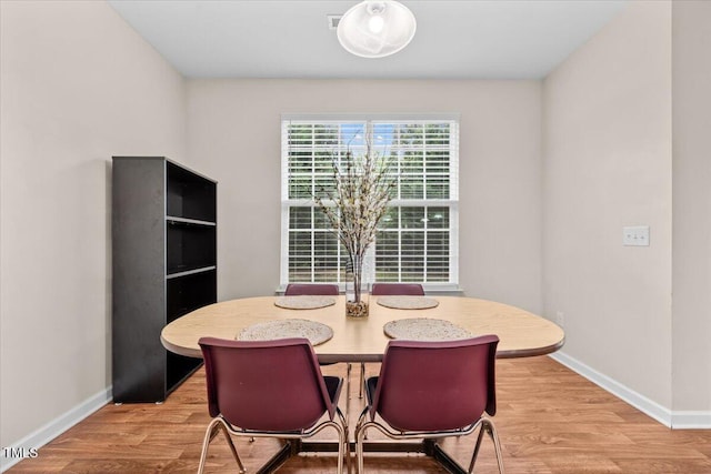 dining area with baseboards and light wood-type flooring