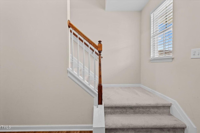 stairs featuring baseboards and carpet flooring