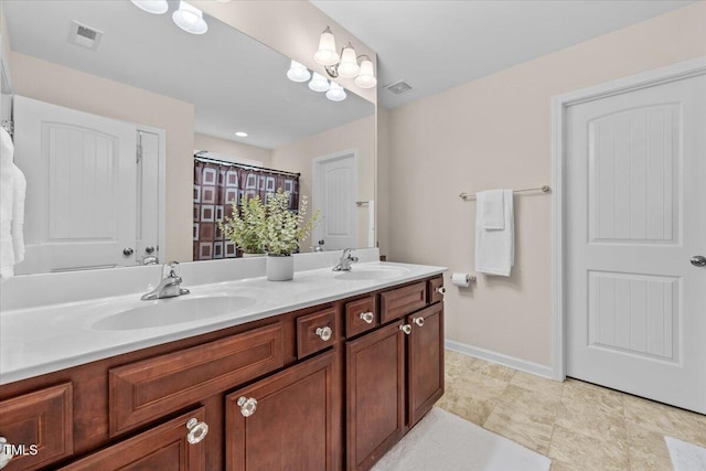 full bathroom with a sink, baseboards, double vanity, and visible vents