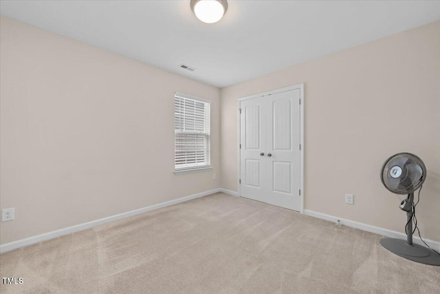 unfurnished bedroom with a closet, baseboards, carpet flooring, and visible vents