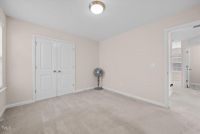unfurnished bedroom featuring baseboards, carpet, and a closet