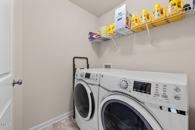 clothes washing area featuring light tile patterned floors, laundry area, washing machine and dryer, and baseboards