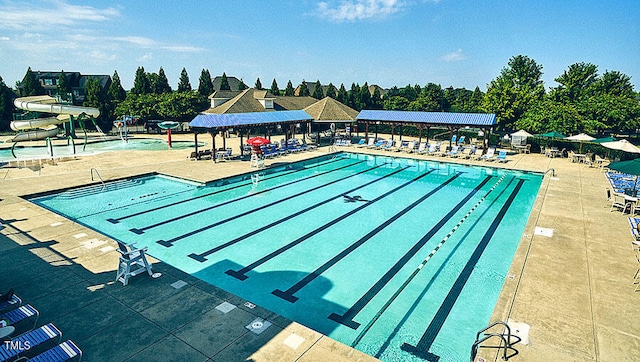 community pool featuring a gazebo, a patio area, and a water slide