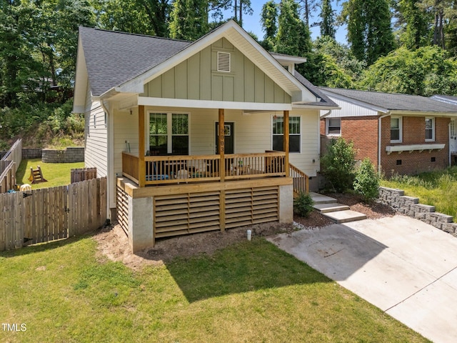 2003 Wa Wa Ave, Durham, NC 27707 - view of front of house featuring board and batten siding, roof with shingles, fence, and a front yard