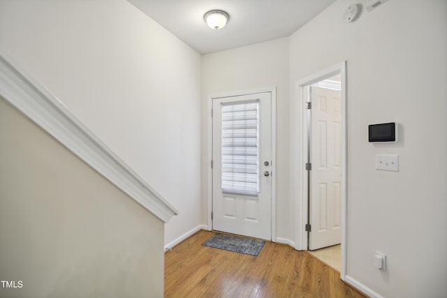entrance foyer with baseboards and light wood-style floors