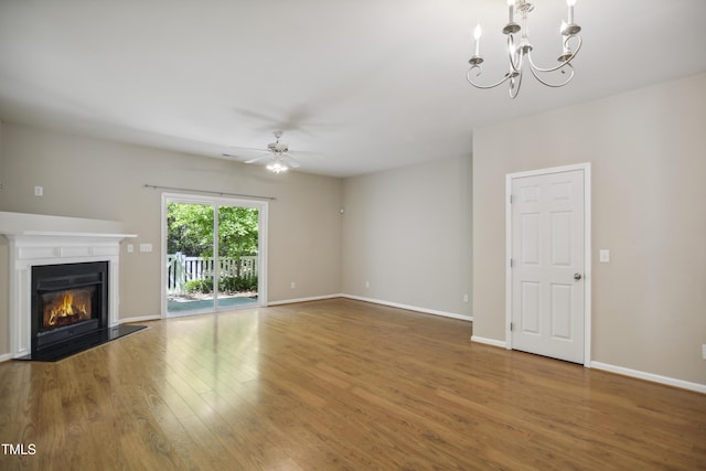 unfurnished living room featuring a glass covered fireplace, baseboards, ceiling fan with notable chandelier, and wood finished floors