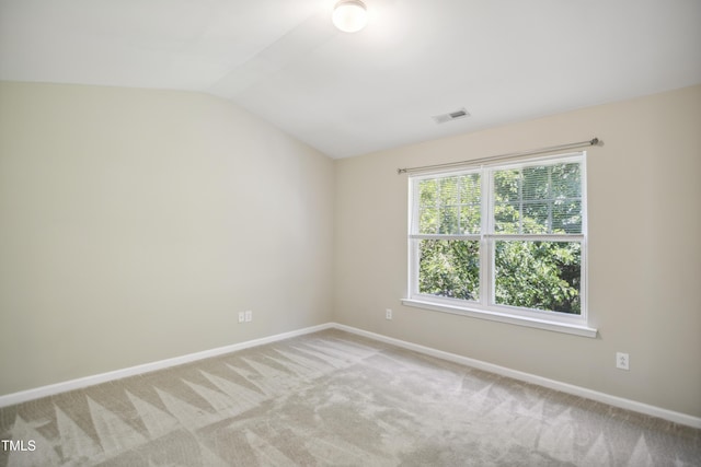 unfurnished room featuring visible vents, carpet, baseboards, and vaulted ceiling