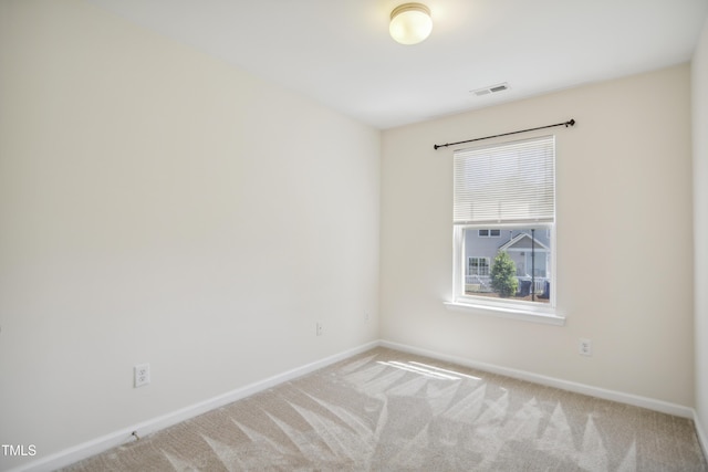 empty room with baseboards, carpet flooring, and visible vents