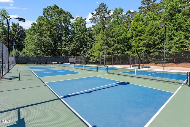 view of tennis court with fence and community basketball court