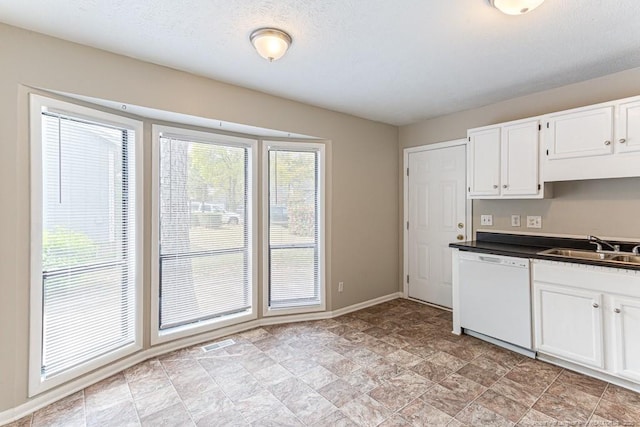 5516 Deep Hollow Ct, Fayetteville, NC 28311 - kitchen featuring stone finish floor, white dishwasher, white cabinets, dark countertops, and a sink